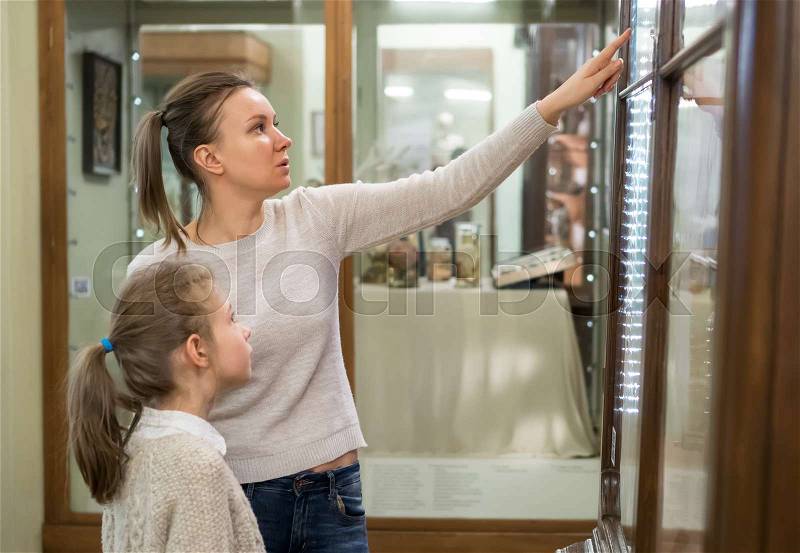 Woman and her daughter exploring expositions in museum, stock photo