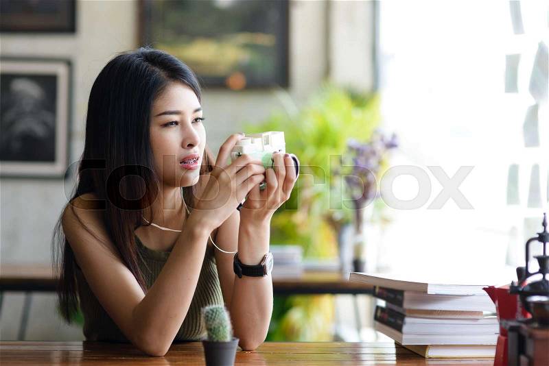 Asian girl is taking a cactus in a coffee shop,hipster lifestyle, stock photo