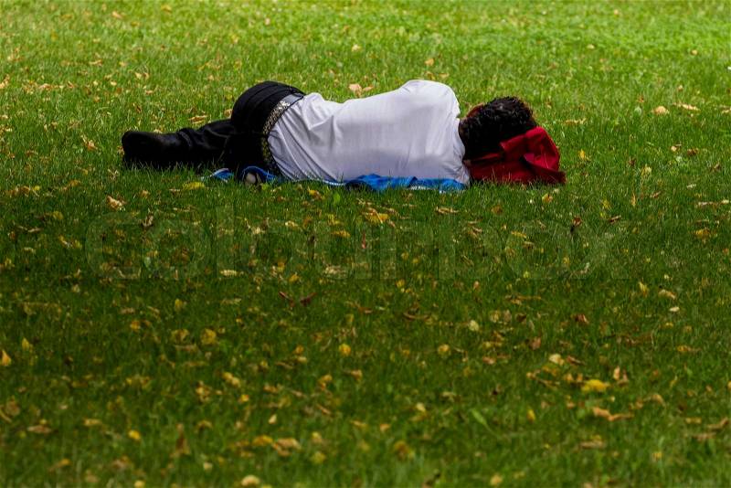 Man is sleeping in a park (volksgarten) in linz, austria, stock photo