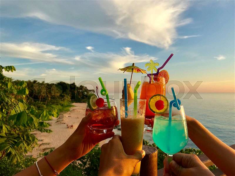 Hands Clinking With Cocktails Glasses Over Beautiful Beach, Sea And Sky Background, Summer Vacation On Tropical Resort, stock photo