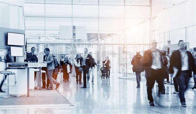 Business people crowd walking in a modern hall at a trade show. ideal for websites and magazines layouts, stock photo
