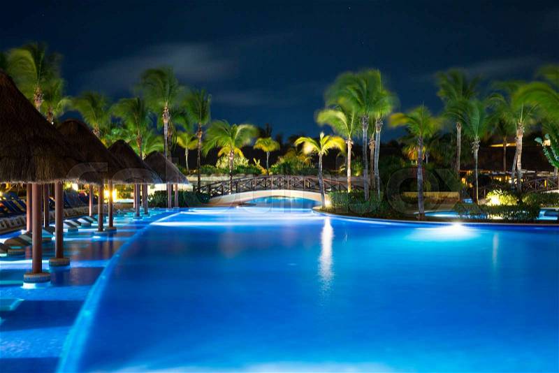 Swimming pool in night illumination. tropical resort at night, stock photo