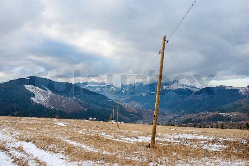 Wooden pillars - electric grids in the winter Carpathian mountain valley, stock photo
