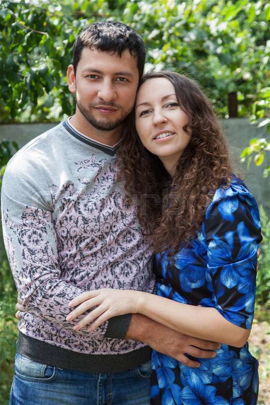 Young couple outdoor sensual portrait on background of green leaves, man muslim and woman european couple in love, stock photo