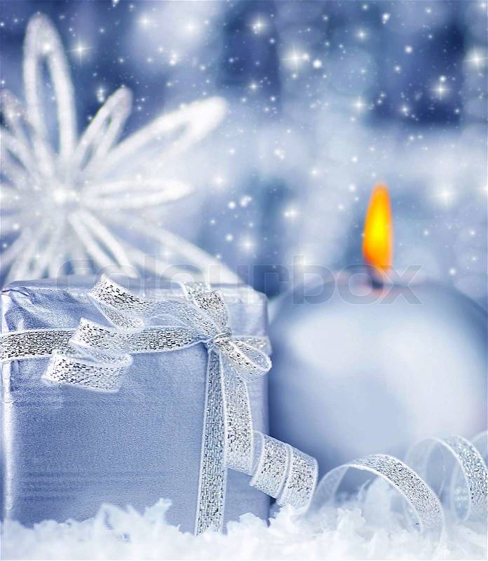 Winter holiday background with blue silver present gift box, candle ornament and Christmas snow decoration, stock photo