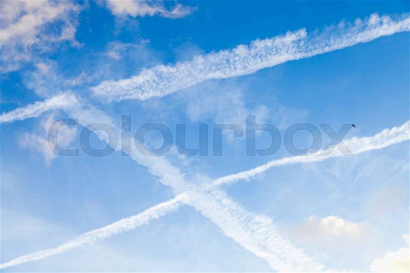 Blue sky with clouds and jet plane trails, background photo texture, stock photo