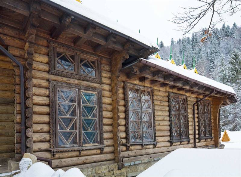 Country wooden house and winter forest behind Carpathian, Ukraine, stock photo