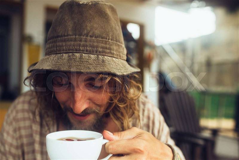 Bearded guy drinking coffee with a white mug, stock photo