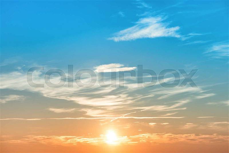 Sunset in the sky with blue orange clouds and big sun, stock photo