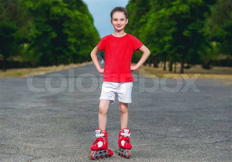 Little girl roller-skating in the summer in the park, stock photo