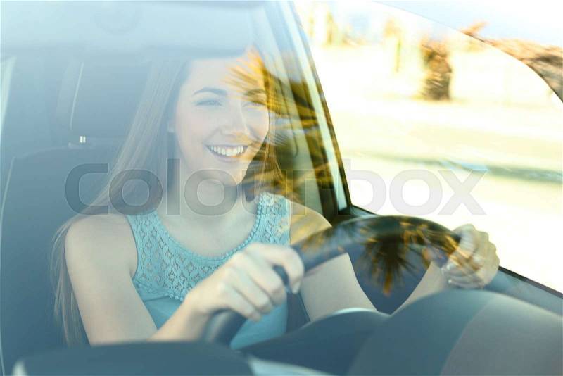 Portrait of a happy attentive driver woman driving a car on the road, stock photo