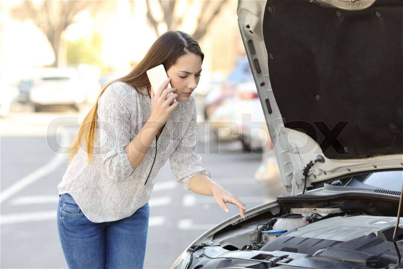 Worried driver with car breakdown calling insurance on the street, stock photo