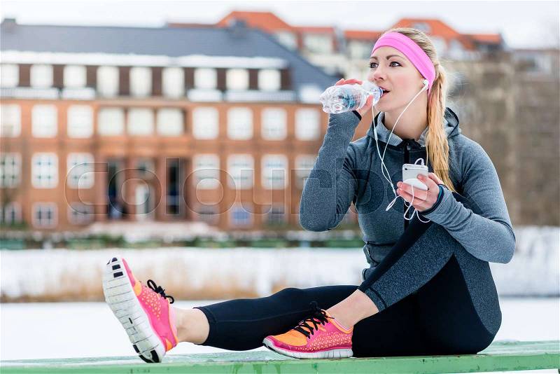 Woman resting from jogging or sport on winter day in the sun, stock photo