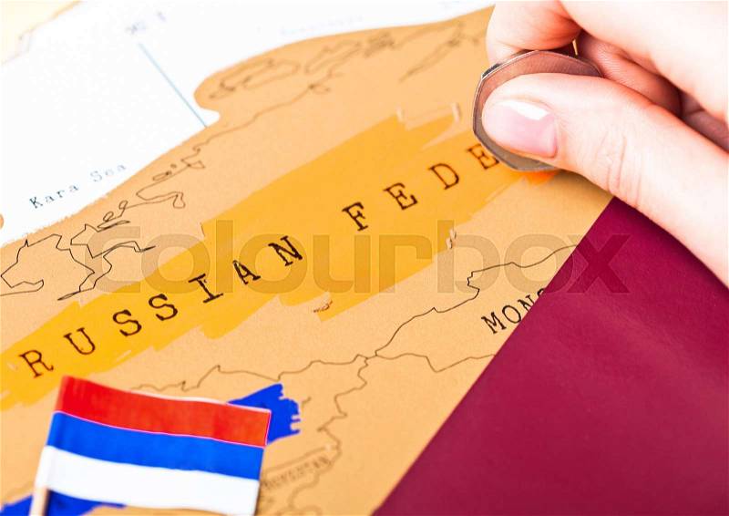 Travel holiday to Russia concept with passport and flag with female hand choosing China on the map, stock photo