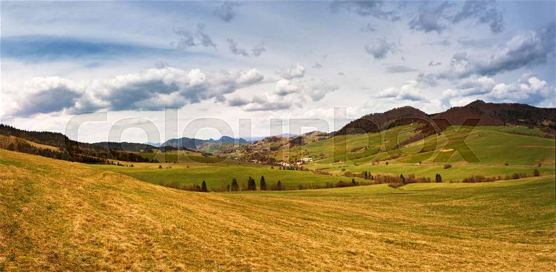 Spring mountain meadow landscape. Panorama of Slovakia Tatras mountains in spring. Mountain village in valley, stock photo