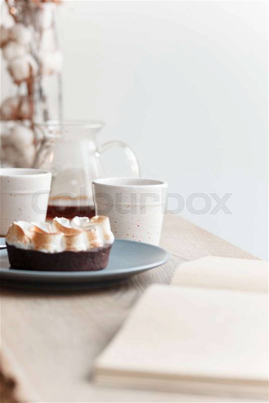 Cup of coffee, branch of tree, wooden windowsill. In the background white window, stock photo