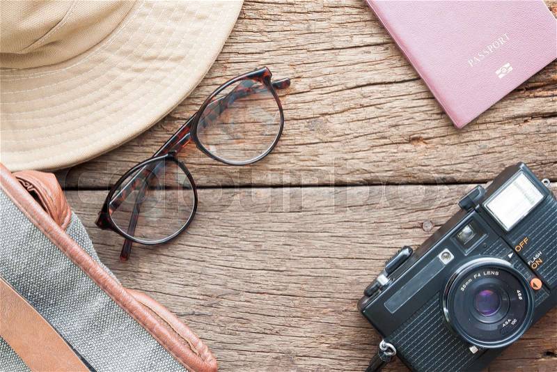 Creative flat lay of eyeglasses, hat, bag, camera and passport on wooden texture background, Travel vacation concept, stock photo