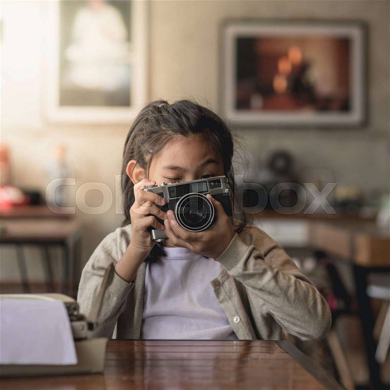 Happy Asian girl holding vintage camera in cafe, lifestyle concept, stock photo