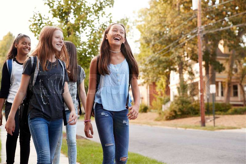 Four young teen girls walking to school, front view close up, stock photo