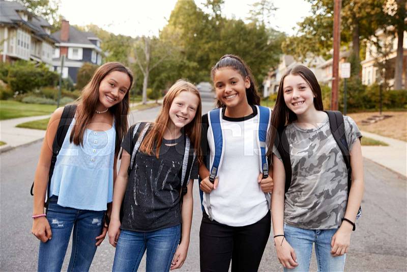 Teen girls on the way to school looking to camera, close up, stock photo