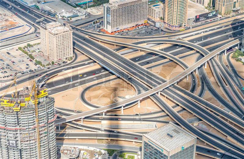 DUBAI, UAE - NOVEMBER 22, 2015: Dubai skyline and road intersection, aerial view. Dubai attracts 30 million people every year, stock photo
