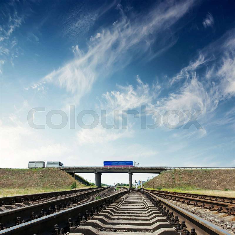 Railroad closeup and bridge with autos under blue sky, stock photo