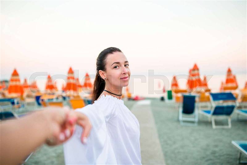 Follow me POV - Couple in love having fun. Boyfriend following girlfriend holding hands on beach smiling enjoying active outdoor lifestyle in Monterosso. Follow me concept, stock photo