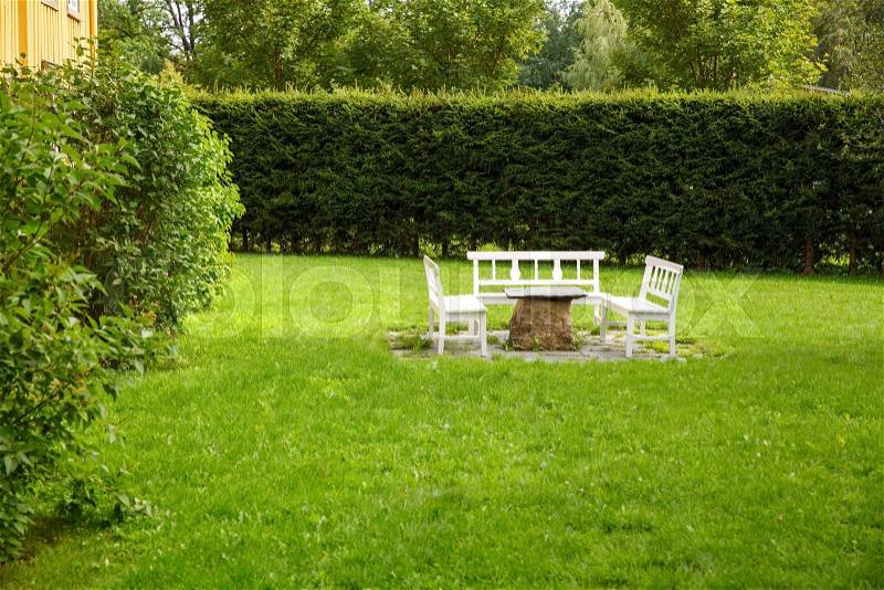 Outdoor furniture made of wood and stone in the garden, stock photo