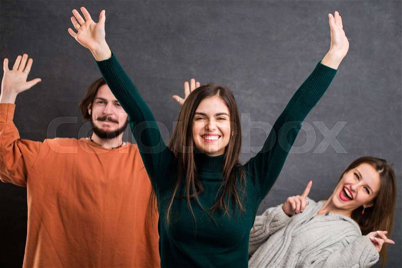 Cheerful teens having fun, happiness concept, indoor shot in the gray background, stock photo