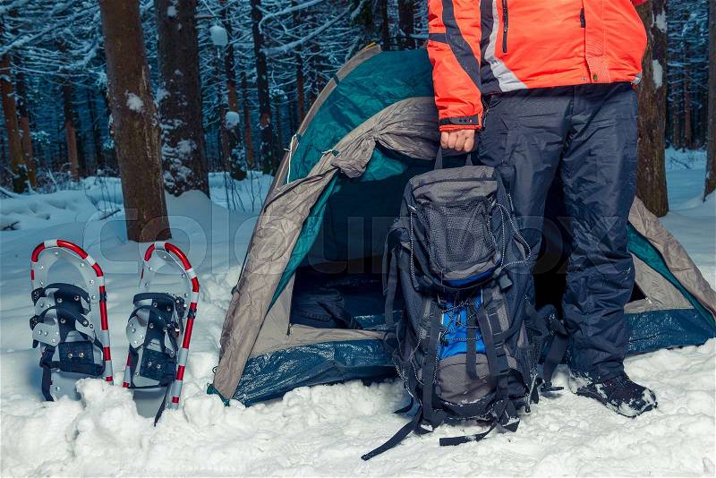 Camping in the winter forest, a man with a backpack, stock photo