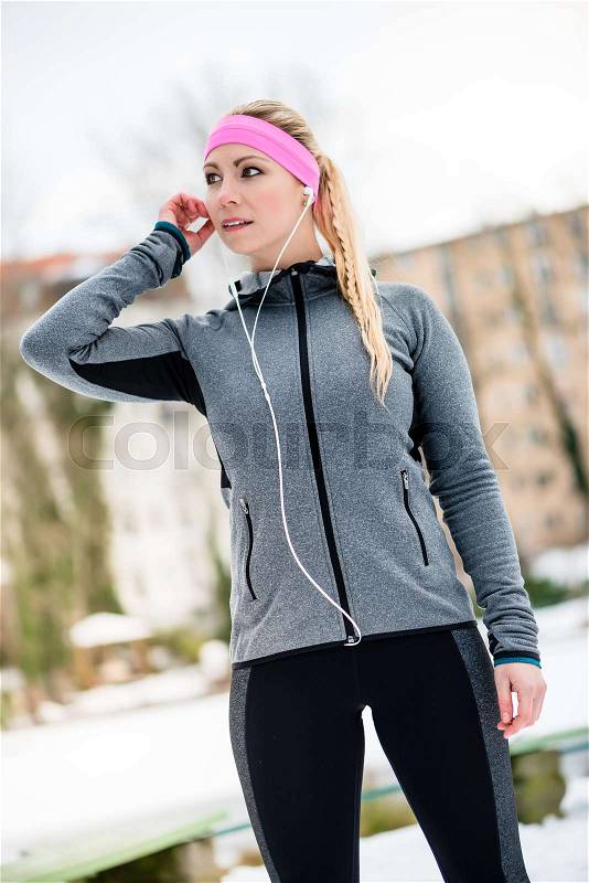Young woman stretching during sport training outdoor on a winter day, stock photo