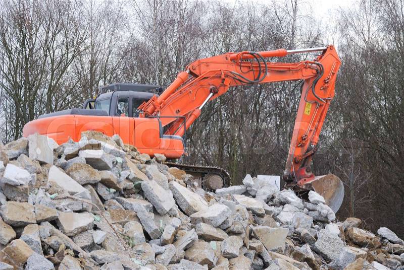 Demolition of a house with an orange digger, stock photo