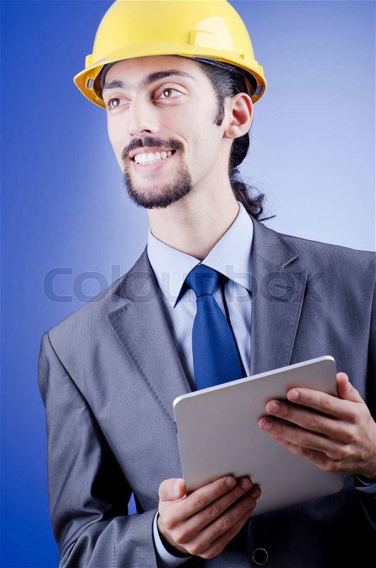 Construction worker working on tablet, stock photo