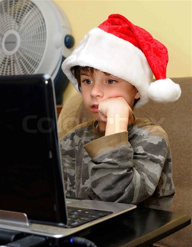 The little boy watches a film on the laptop, stock photo