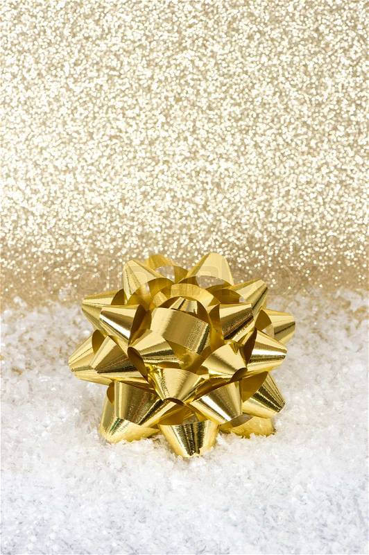 Golden ribbon in snow decoration over golden shiny background, stock photo