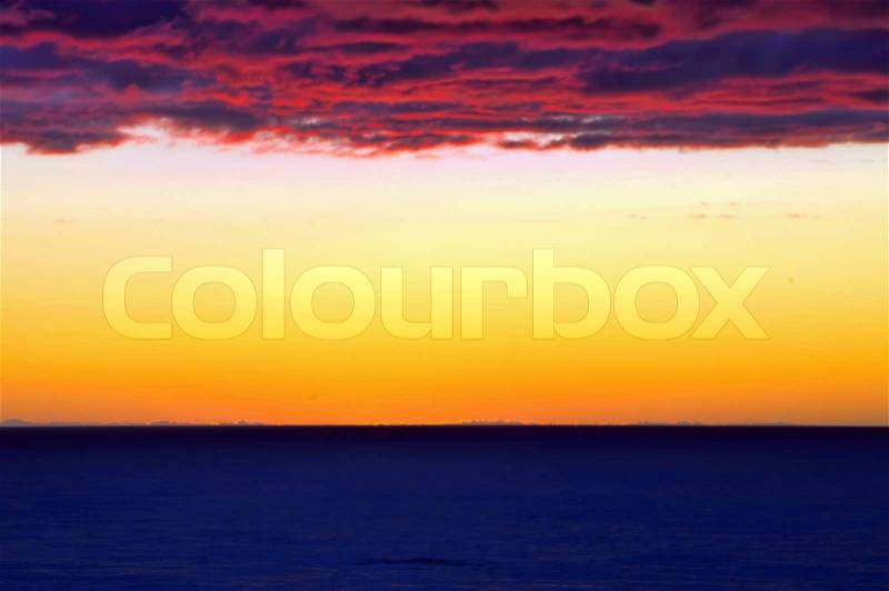 A sunset background divided by sea, sky and coloured sky, stock photo