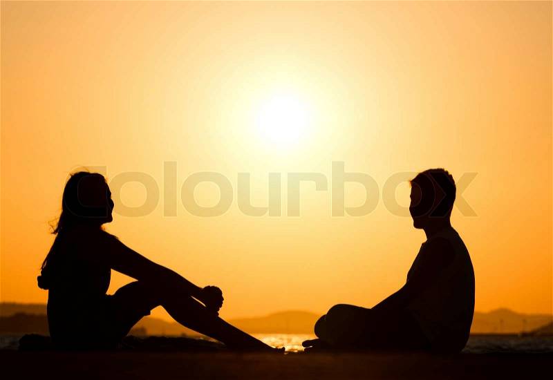 Silhouette picture of young friends during sunset, stock photo