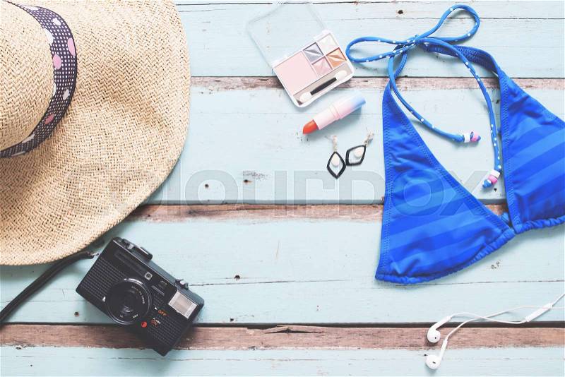 Overhead view of Woman\'s essentials summer vacation concept on vintage blue wooden background, stock photo