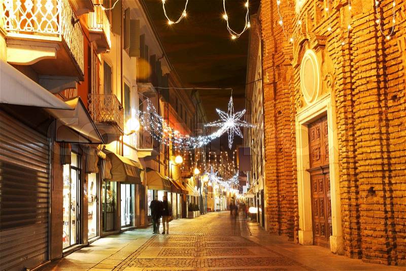Alba old town central street with opened shops, bars and stores and illuminations for Christmas and New Year holidays, stock photo