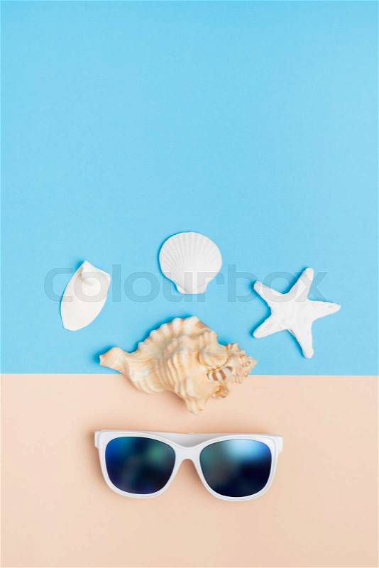 Set of summer object sunglasses,shell,starfish on pastel beige and blue background vertical.Holiday vacation backdrop.Copy space for display of product or content design, stock photo