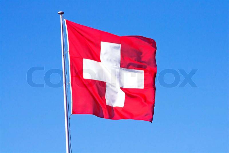 Swiss flag against blue sky, stock photo