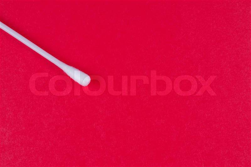 Cotton bud on red background close up, stock photo