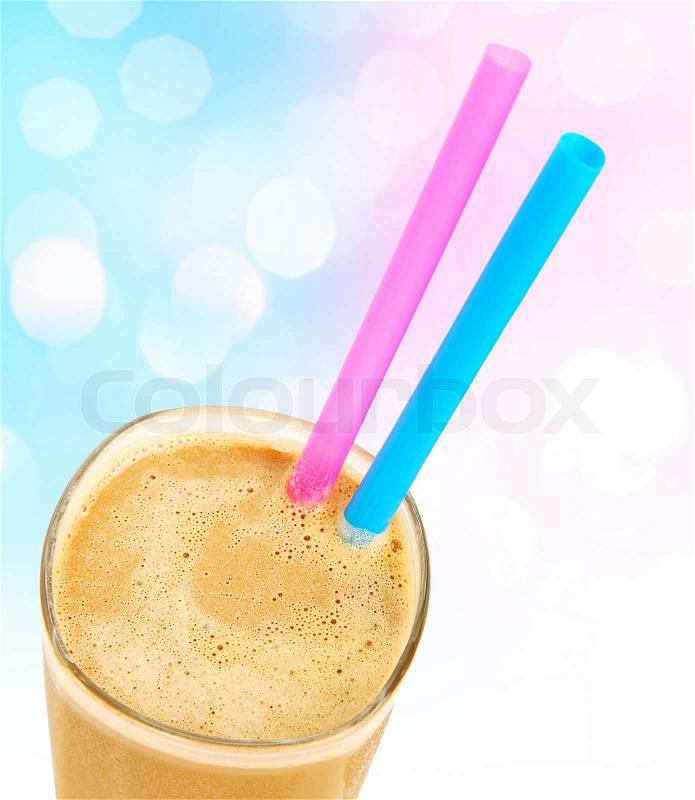 Cold coffee drink with colorful straws isolated over bokeh blue pink background, stock photo