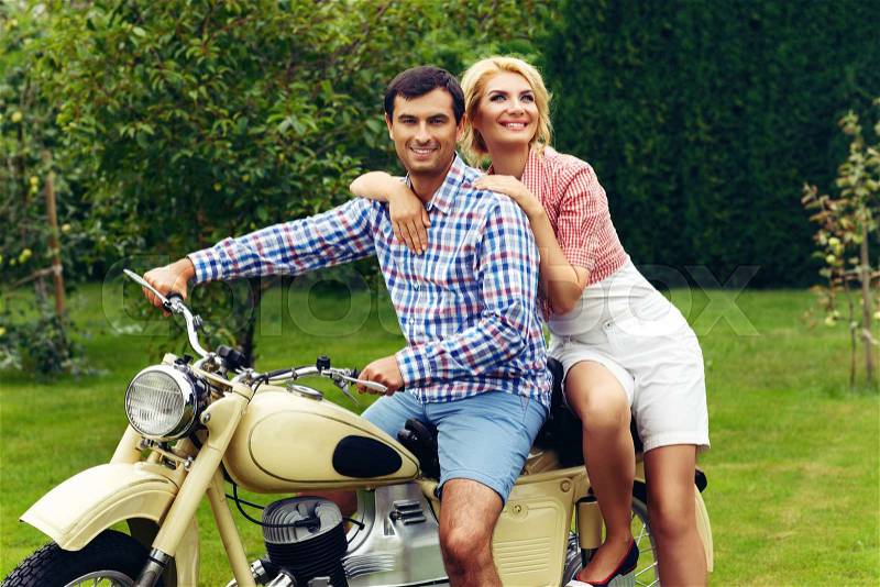 Beautiful woman and hansome man on retro intage motorbike. couple in love. outdoor shot with ambient light. copy space, stock photo