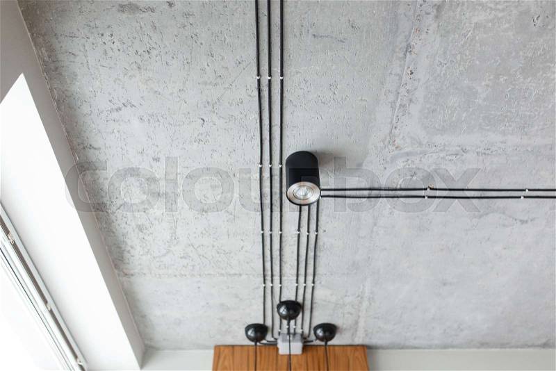 Black wire and led spot lights on the concrete ceiling for new construction building. Modern loft style, stock photo