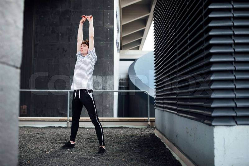 Freerunner is stretching on a rooftop. , stock photo
