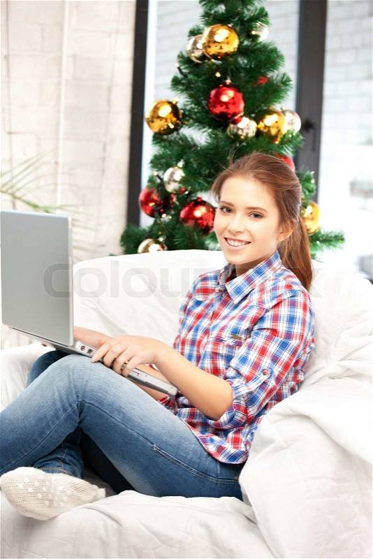 Picture of happy woman with laptop computer and christmas tree, stock photo