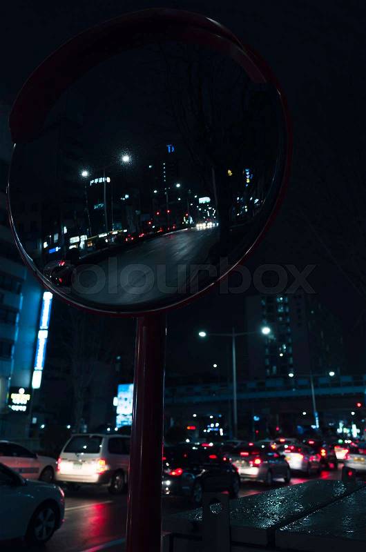 Night street of Busan city, round road mirror with blurred cars stoplights , stock photo