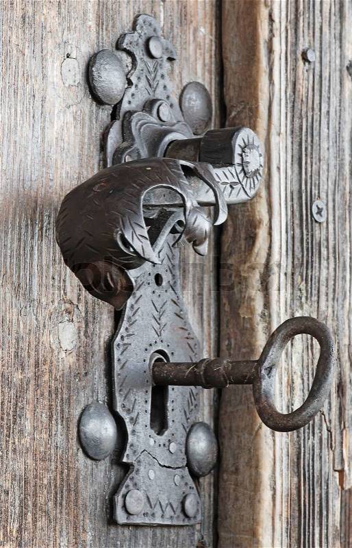 An old metal handle at wooden door, stock photo