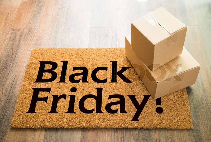 Black Friday Welcome Mat On Wood Floor With Shipment of Boxes, stock photo